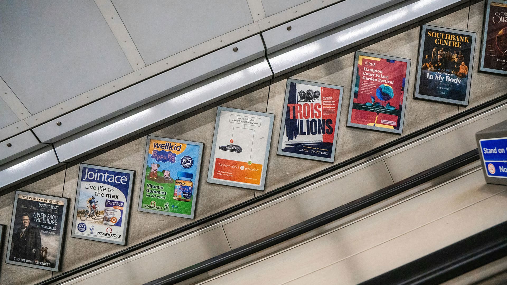 Flyers displayed along an escalator in a public space, showcasing diverse designs