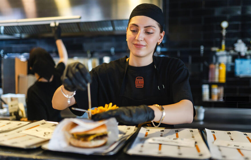 GERRR BURGER employee preparing food, showcasing the brand's attention to quality and service in a professional kitchen environment